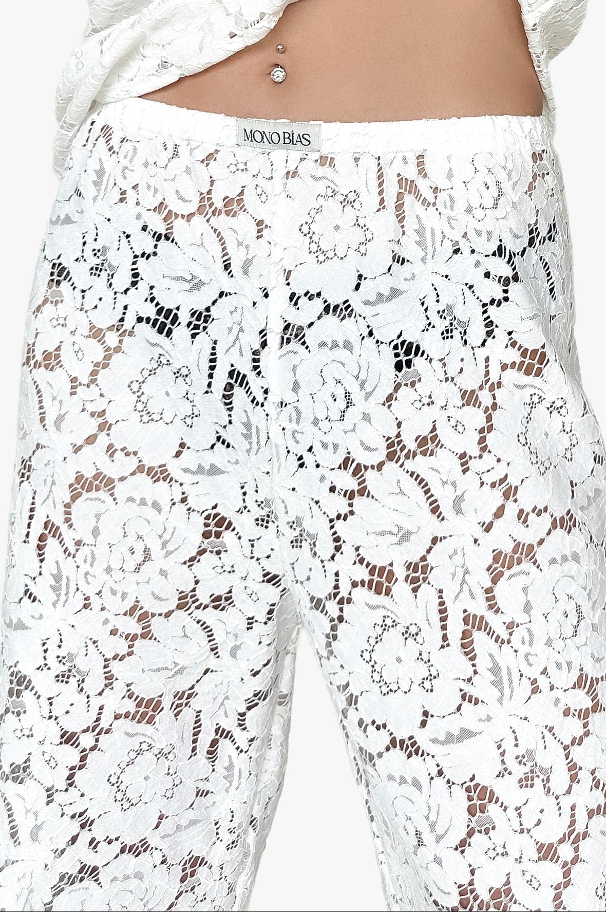 White lace pants with floral patterns on a white background